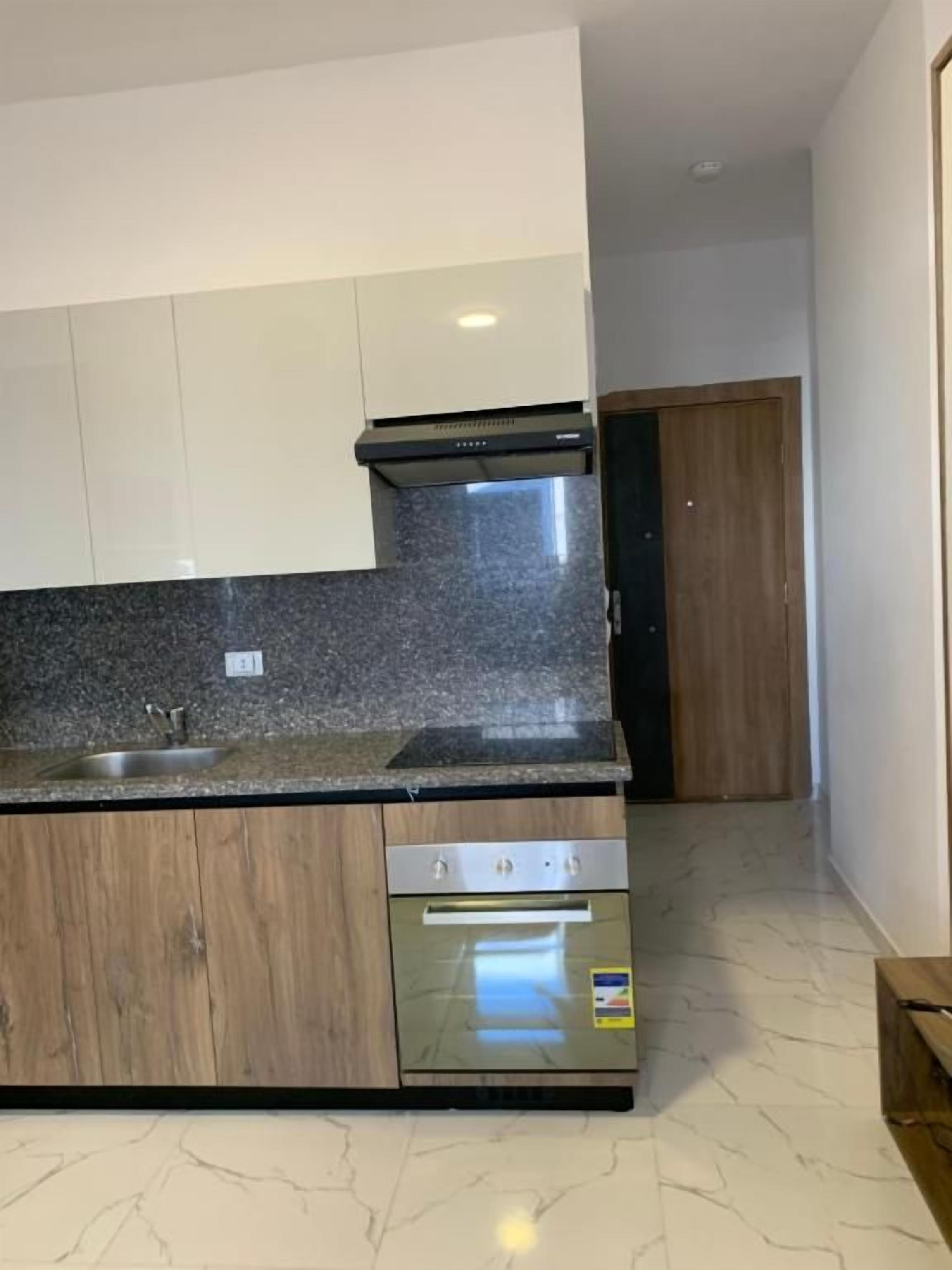 A kitchen with a granite countertop, stainless steel appliances, and wooden cabinets.