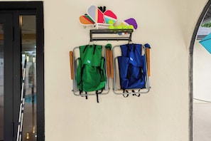 A wall-mounted rack with two bags and a set of colorful paddles. - Pickleball- Heated Pool - Game Room - Themed Rooms (Sarasota)