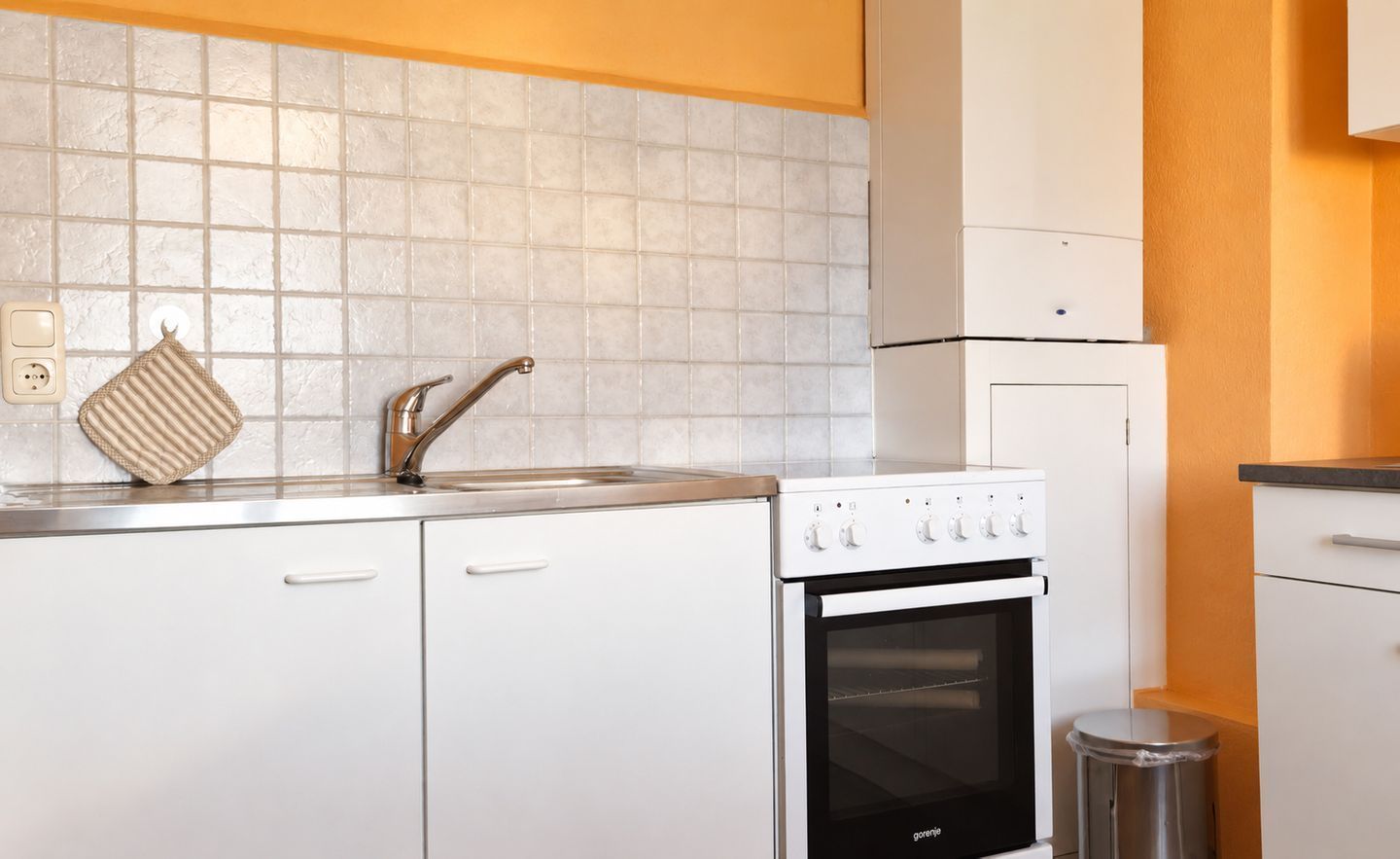 Una cocina con estufa, horno y lavamanos.