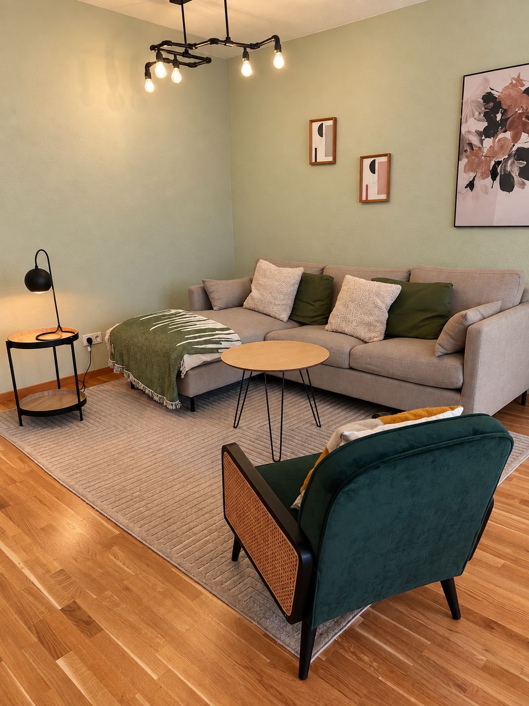 A modern living room with a sofa, a coffee table, a chair, a lamp, and artwork on the wall.