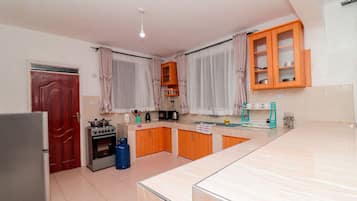 Uma cozinha com geladeira, fogão e armários de madeira.