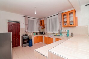 Uma cozinha com geladeira, fogão e armários de madeira.