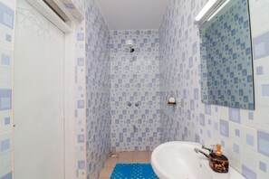 A bathroom with a white sink, a mirror, and a shower area with tiled walls. - Naivasha View Palace Apartment (Karagita)