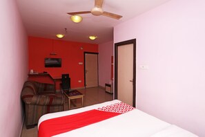 A hotel room with a bed, a television, a desk, a chair, and a ceiling fan. - Collection O Kamala Inn Dankuni (Shrirampur)