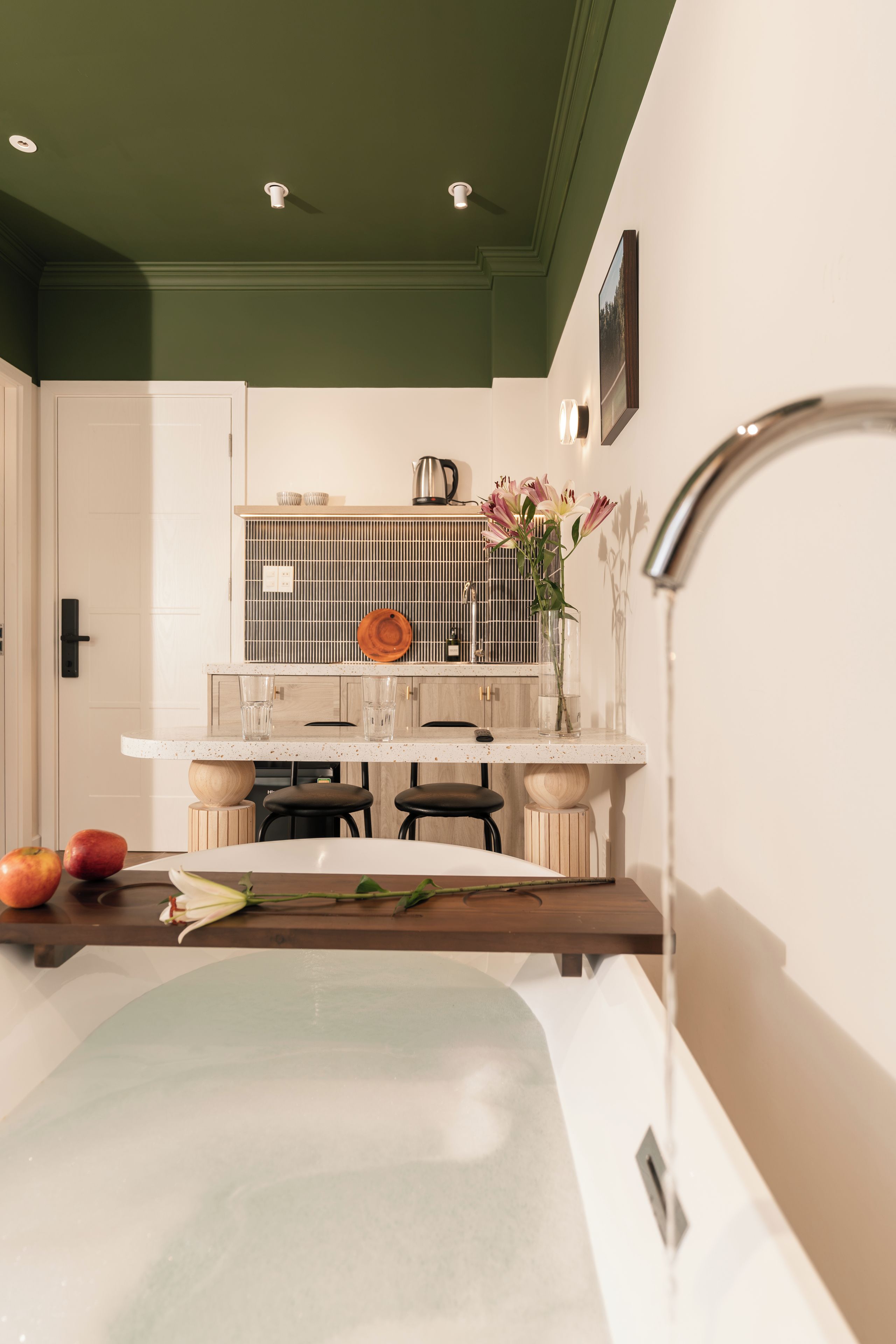 A modern kitchen with a central island, a sink, and a dining area with chairs.