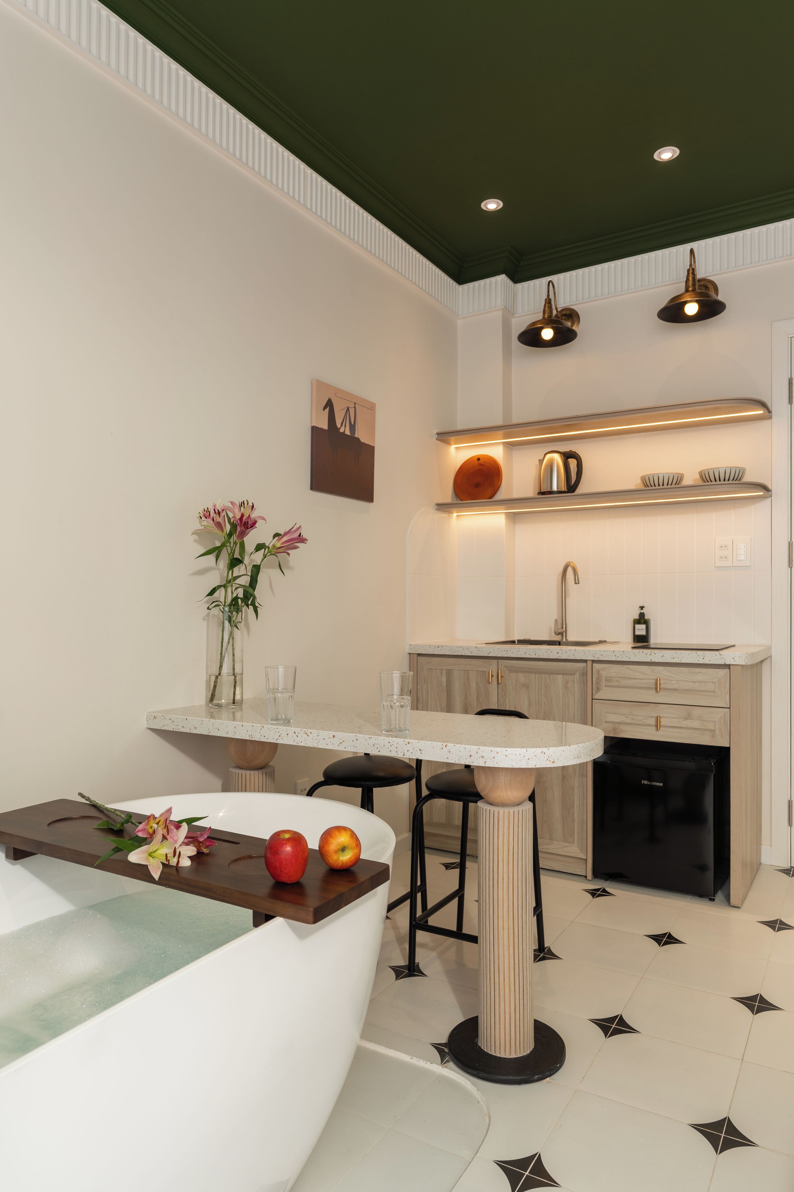 A modern kitchen with a central island, a dining area, and a kitchen counter with overhead lighting.