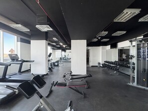 Ein Fitnessstudio mit Laufbändern, Kraftgeräten und Kurzhanteln.