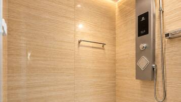 A modern shower with a control panel, a handheld showerhead, and a handheld shower attachment.