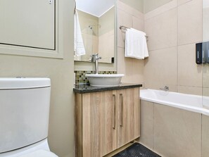 A bathroom with a toilet, sink, and bathtub. - Regentis Executive Stays at The Atrium unit 166 (City of Johannesburg Metropolitan Municipality)