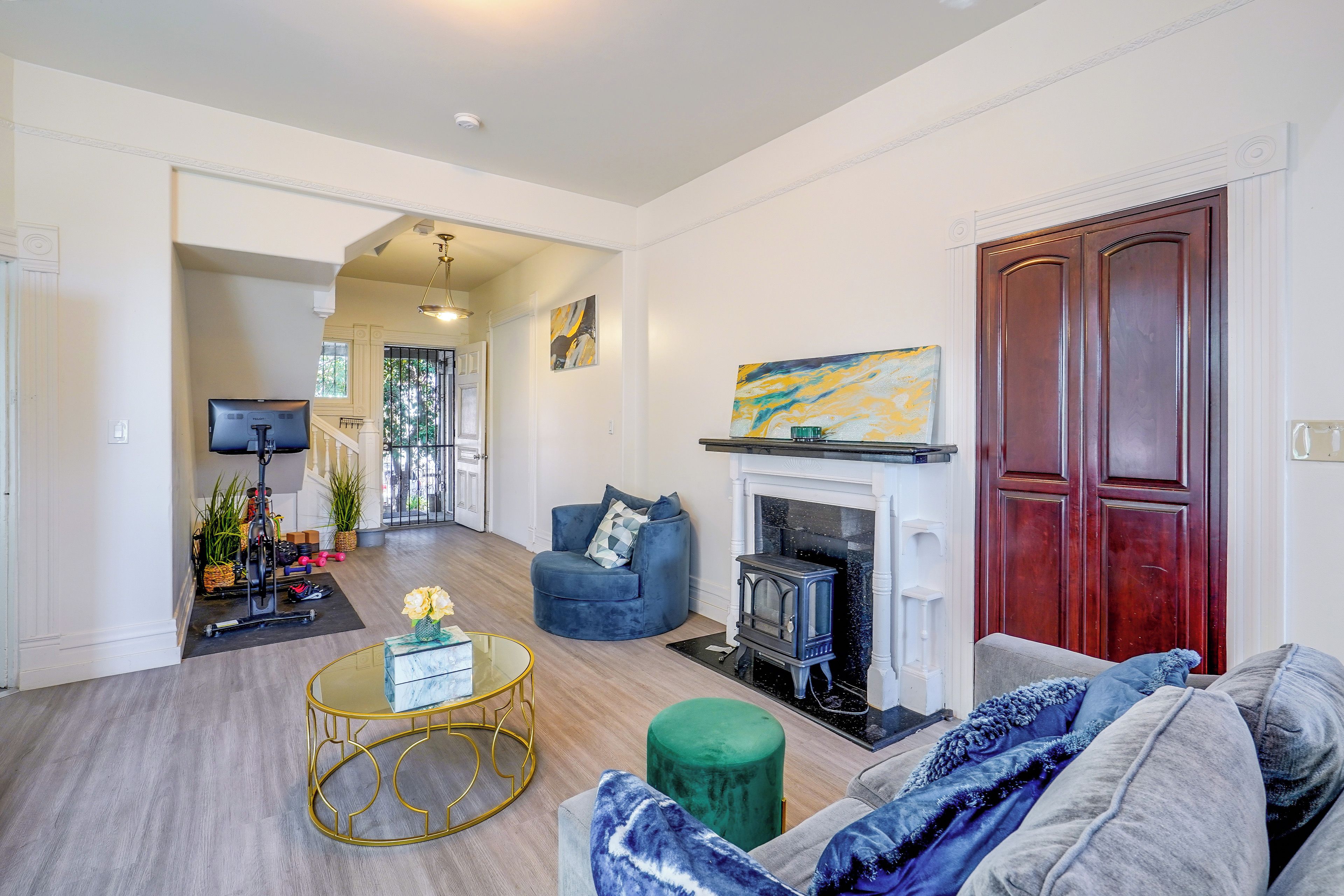 A living room with a fireplace, a blue sofa, a green ottoman, and a round coffee table.
