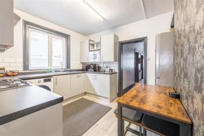 Een moderne keuken met een centraal eiland, een magnetron en een koelkast.