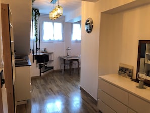 A modern kitchen with a dining area, wooden flooring, and a pendant light fixture. - Le Bicoquet in Caen: An Elegant and Cozy Apartment (Caen)