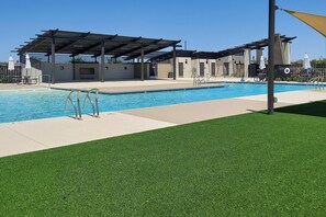 A swimming pool with a covered area, a lifeguard stand, and a grassy area. - Pool & Hot Tub Access! Goodyear Extended Escape (Goodyear)