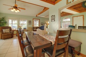 A dining area with a long wooden table, chairs, and a ceiling fan. - Grand Lake Escape: Deck, Hot Tub, Views! (Eucha)