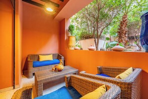 Una zona d'estar a l'exterior acollidora, amb mobles de vimetla i testos de terracota.