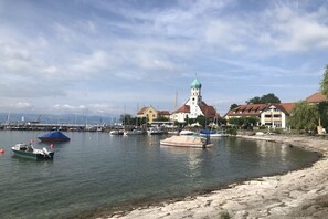 A marina with boats, a church with a green dome, and residential buildings. - Holiday apartment with 2 bedrooms (Bodolz)