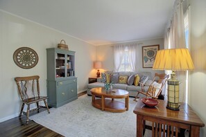 A living room with a sofa, a wooden chair, a coffee table, a cabinet, and a lamp. - Game Room & Foosball! Fayetteville Family Home (Fayetteville)