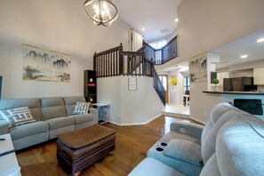 A modern living room with a staircase, a sofa, a coffee table, and artwork on the walls. - 5 Mi to Toyota Music Factory! Unit w/ Pool Access (Irving)