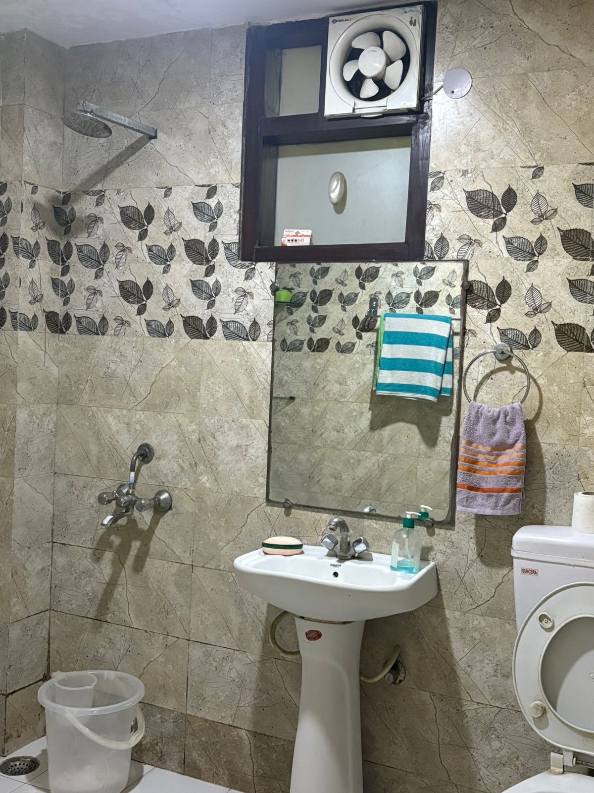 A bathroom with a sink, toilet, and shower.