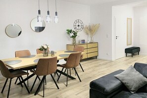 Ein Essbereich mit Holztisch, Stühlen und einer modernen Leuchte.