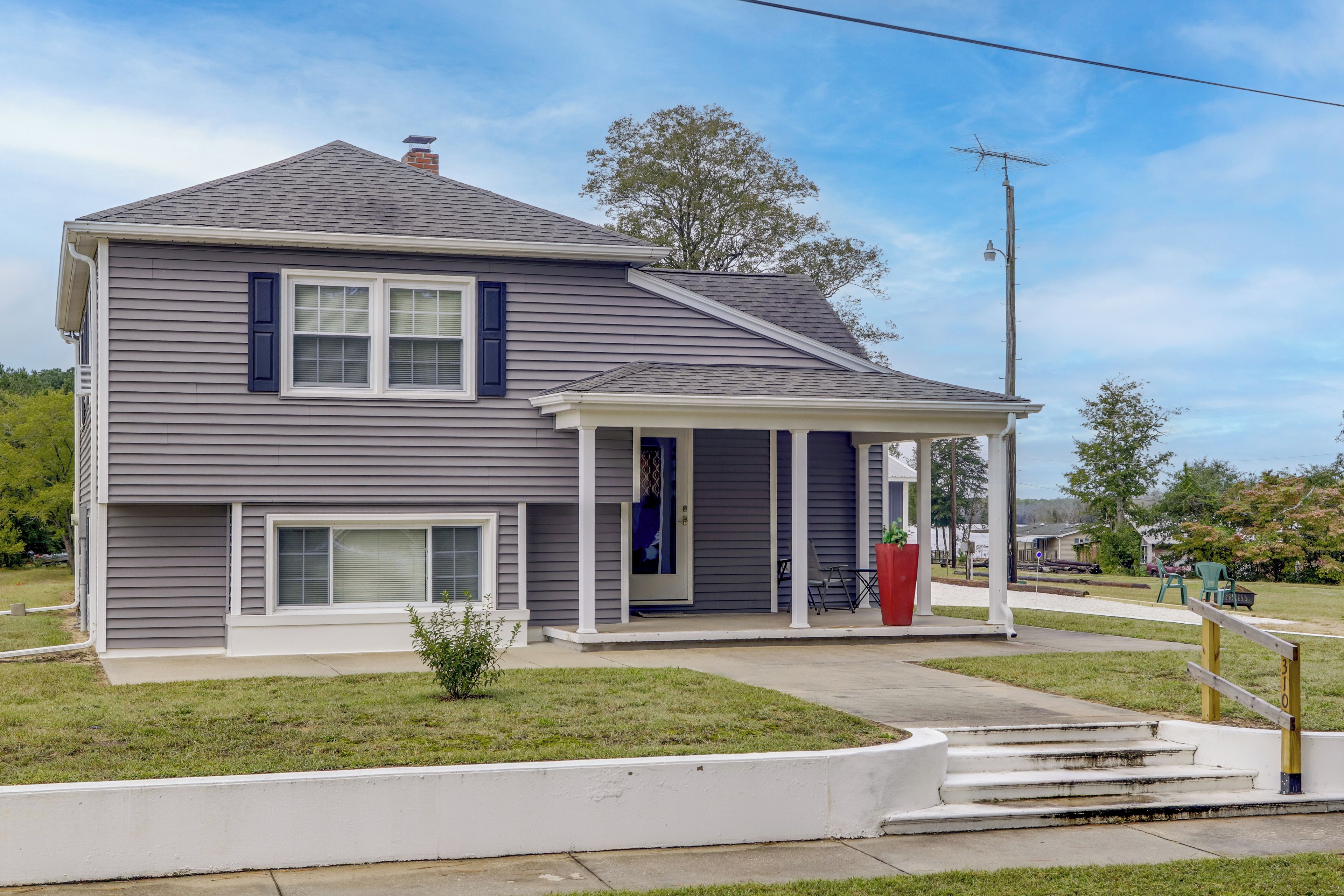 A two-story house with a front porch, a small front yard, and a visible mailbox.