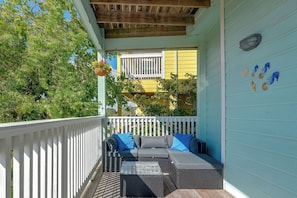 A covered outdoor seating area with wicker furniture and a white railing. - Steps to Sylvan Beach Park! Family Getaway (La Porte)