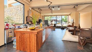 Una cocina moderna con una isla central de madera, una pared de piedra y vistas a la calle.