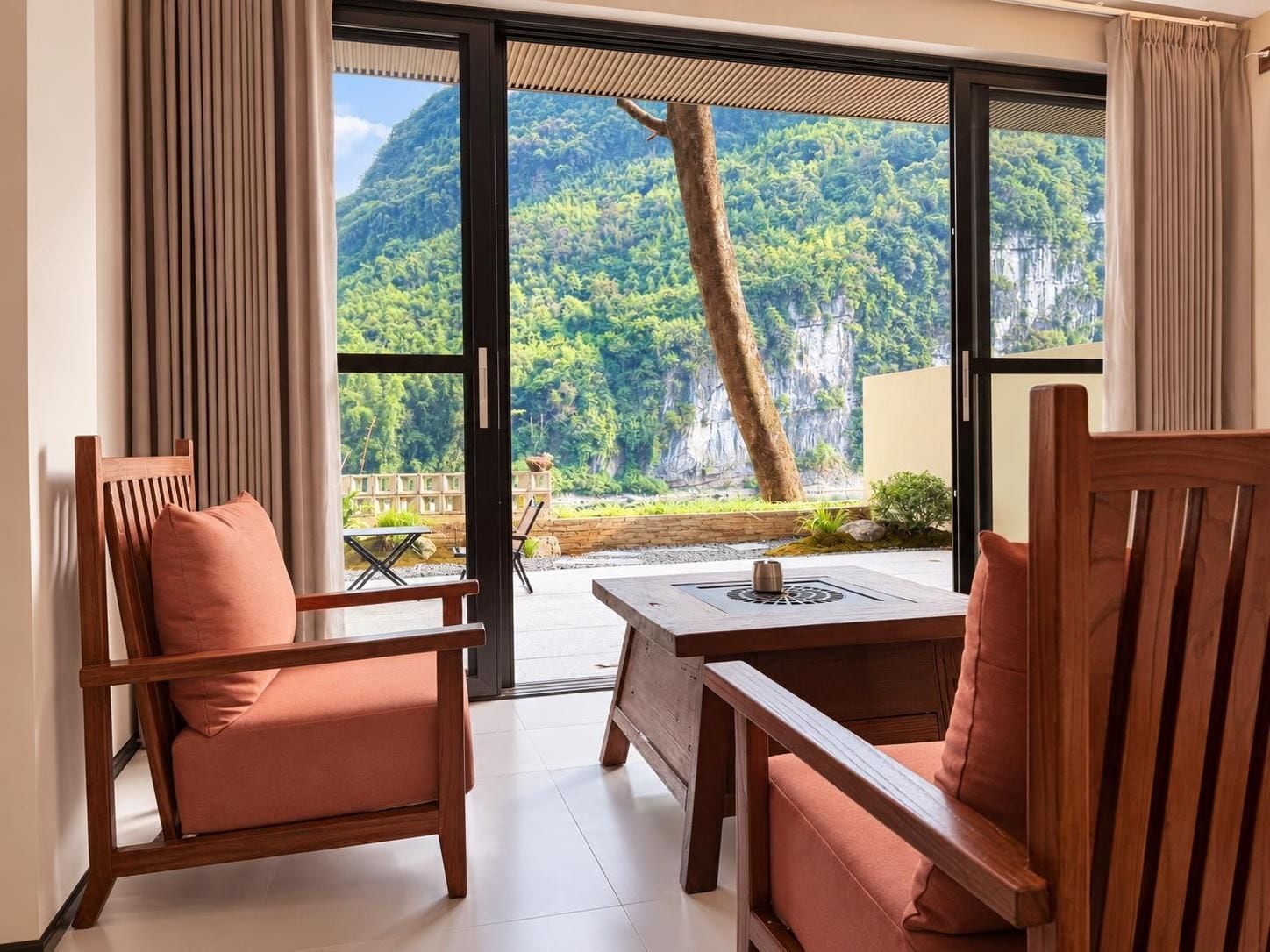 A room with a sliding glass door leading to a balcony with a mountain view.