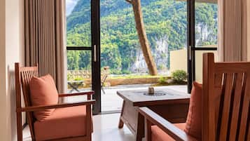 A room with a sliding glass door leading to a balcony with a mountain view.