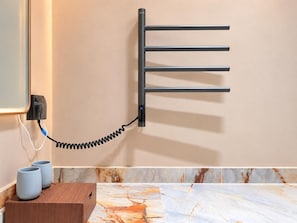 A wall-mounted towel rack with a coiled cord, a power outlet, and two cups on a wooden surface. - TMAN RESORT (Guilin)