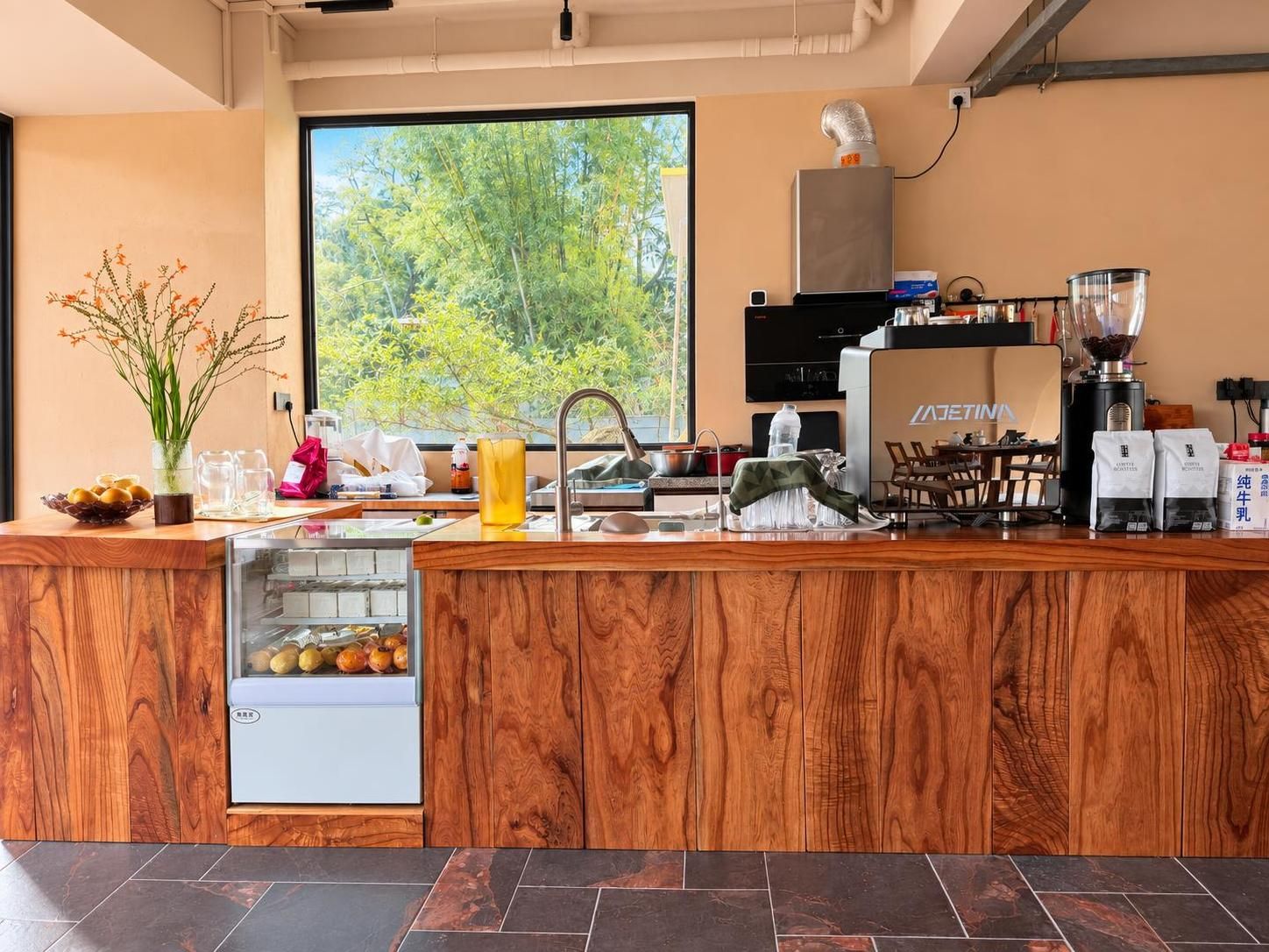 Una cocina moderna con encimera de madera, una cafetera y vistas a zonas verdes.