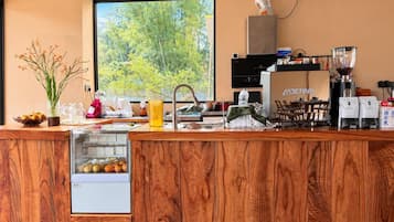 Una cocina moderna con encimera de madera, una cafetera y vistas a zonas verdes.