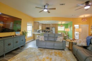 A living room with a gray sofa, a blue cabinet, and a patterned rug. - Pine Island Escape: Fish, Hike & Bird-Watch (Bokeelia)