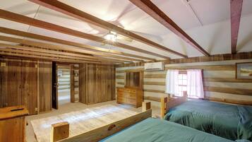 A cabin with a loft bed, a wooden wardrobe, and a ceiling fan.