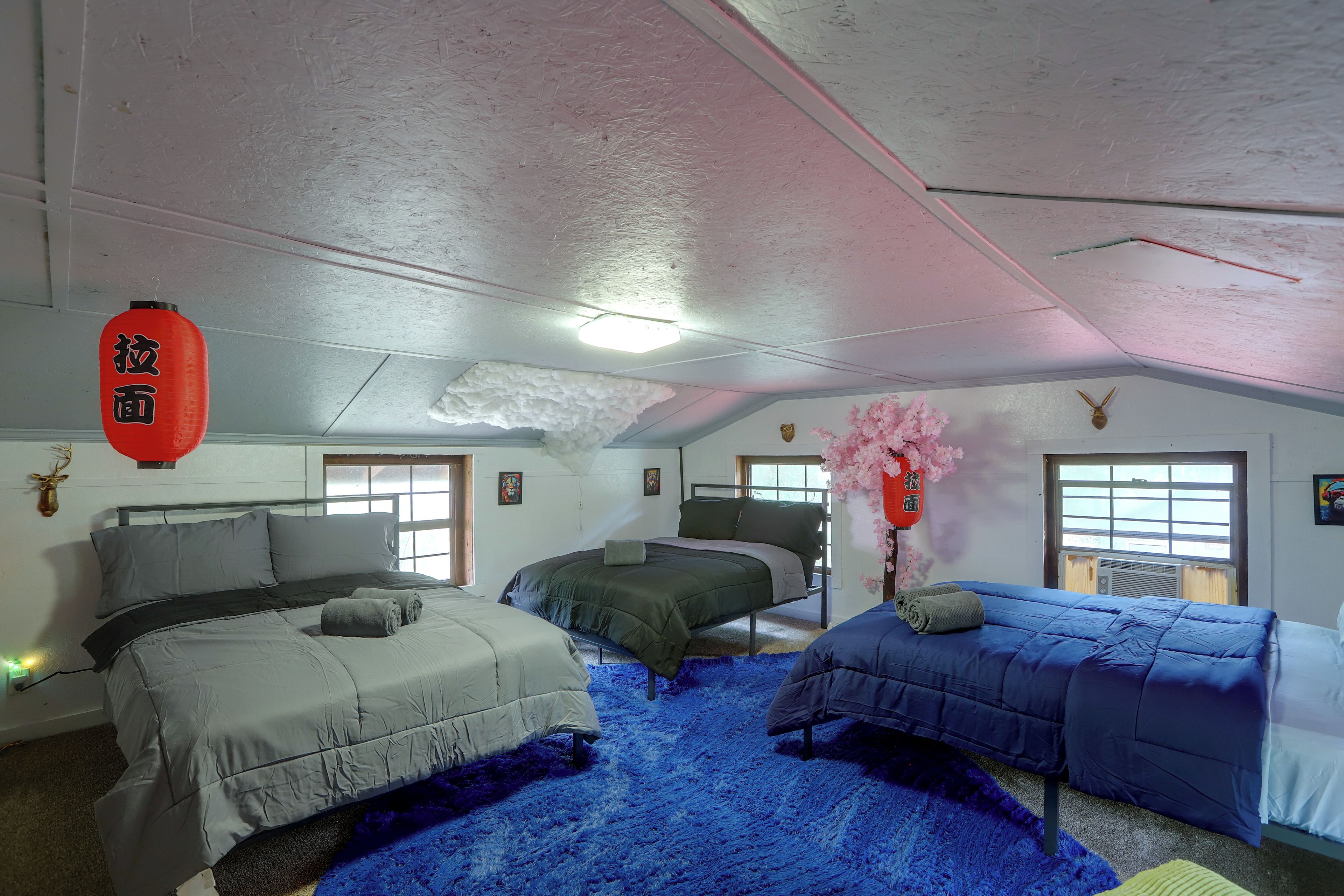 A room with two beds, a window, and a ceiling with insulation.