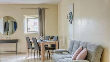 A dining area with a table, chairs, and a mirror.