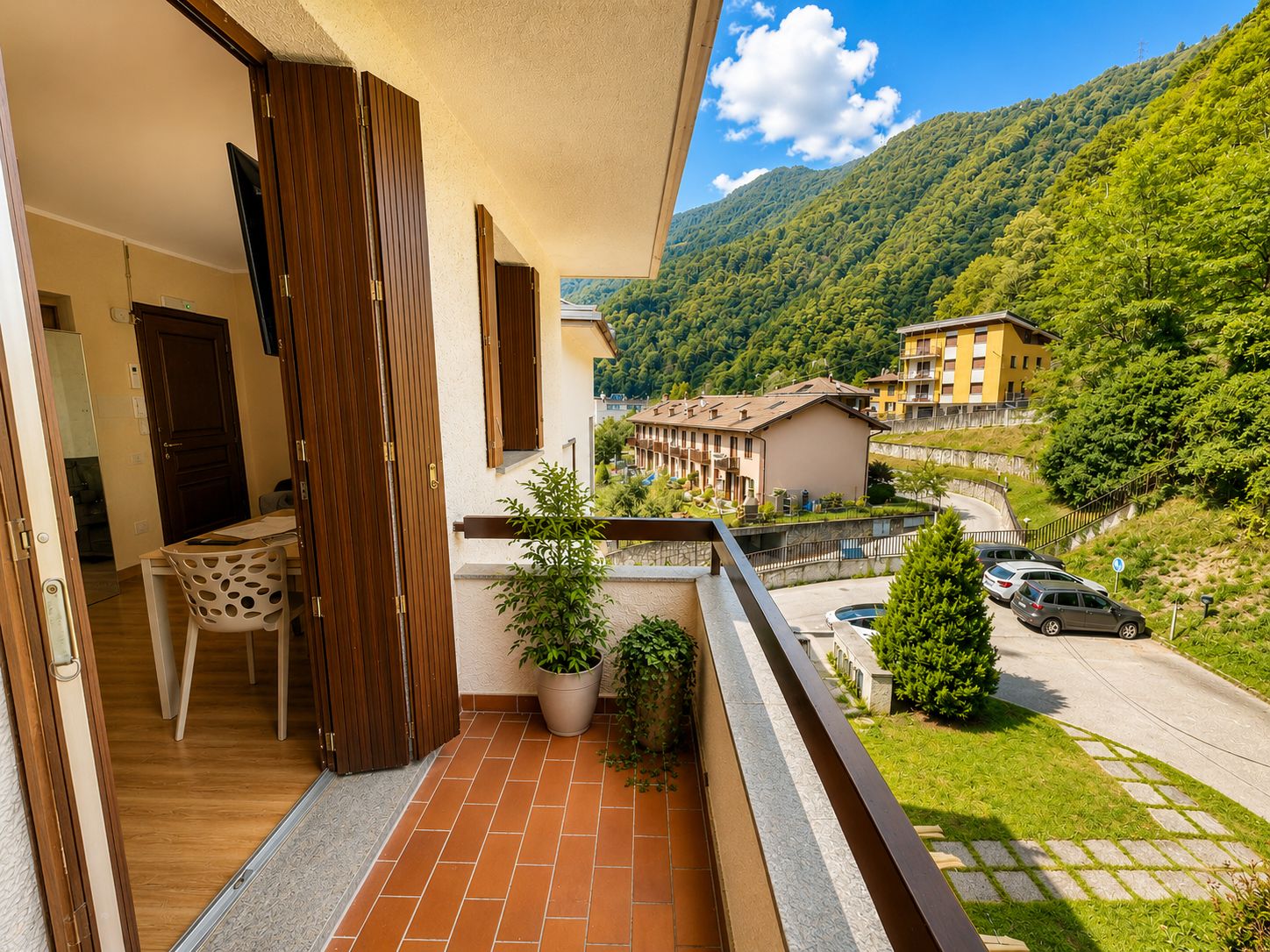 Ein Balkon mit Blick auf einen Berg, einem Stuhl und einem Blumentopf.