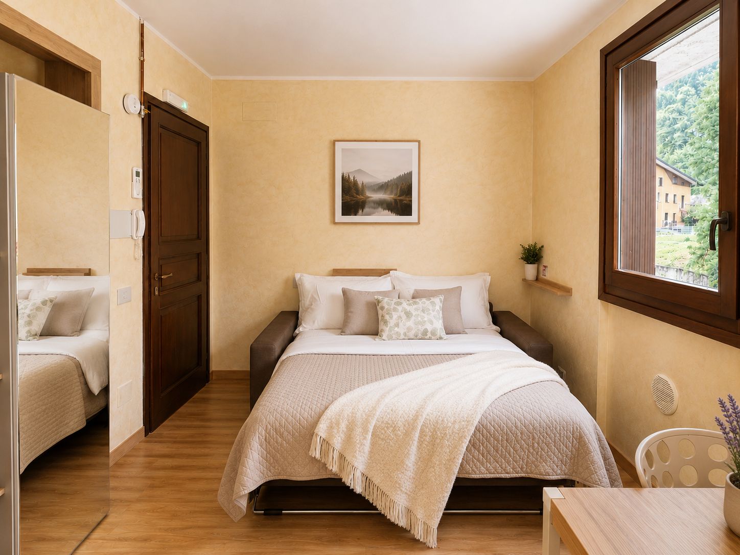Ein Schlafzimmer mit Bett, Nachttischen, einem Fenster und einer Tür.