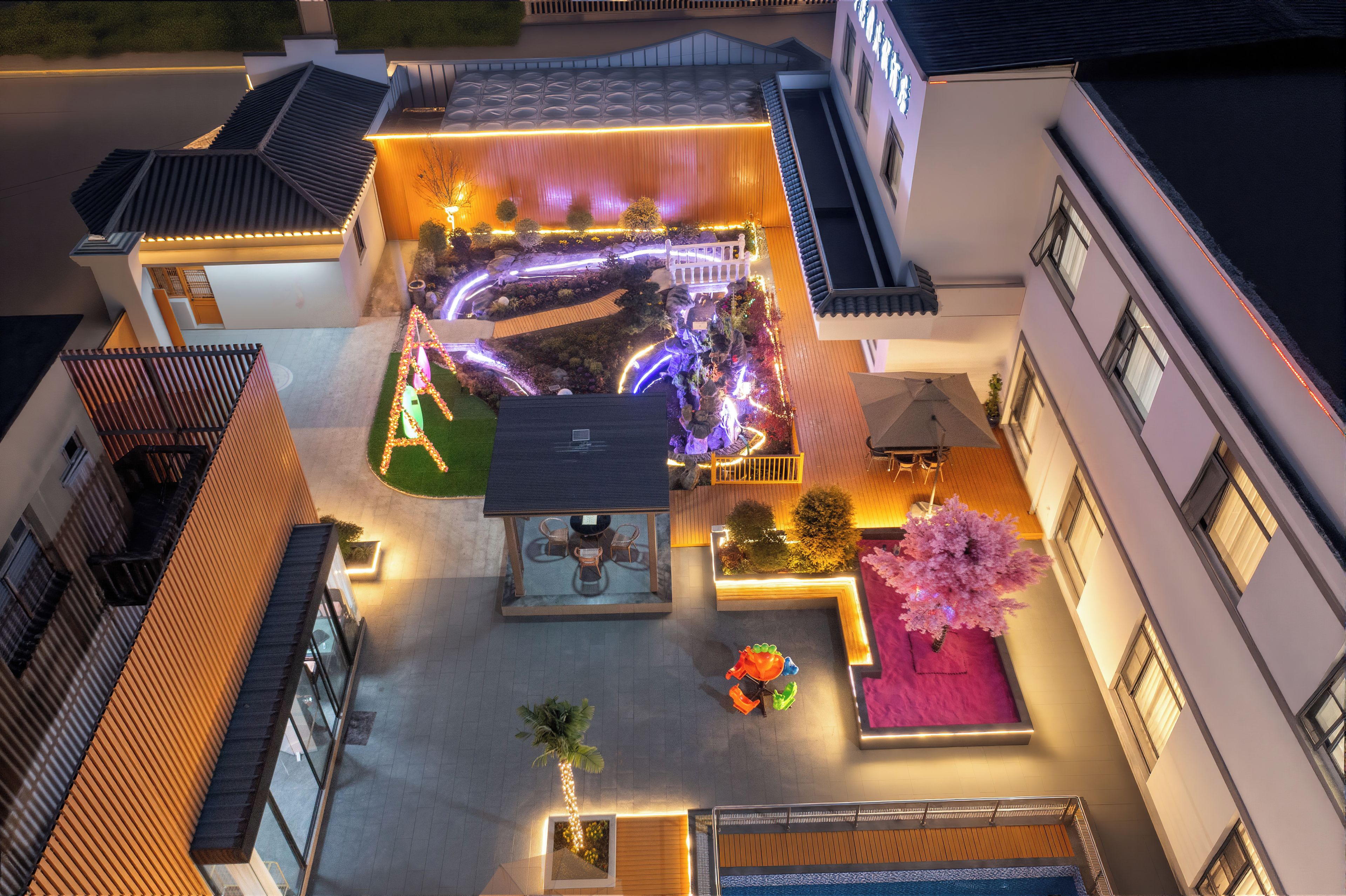 A rooftop garden with a seating area, a small pool, and a decorative tree.