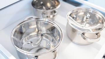 Three stainless steel cups with lids on a white tray.