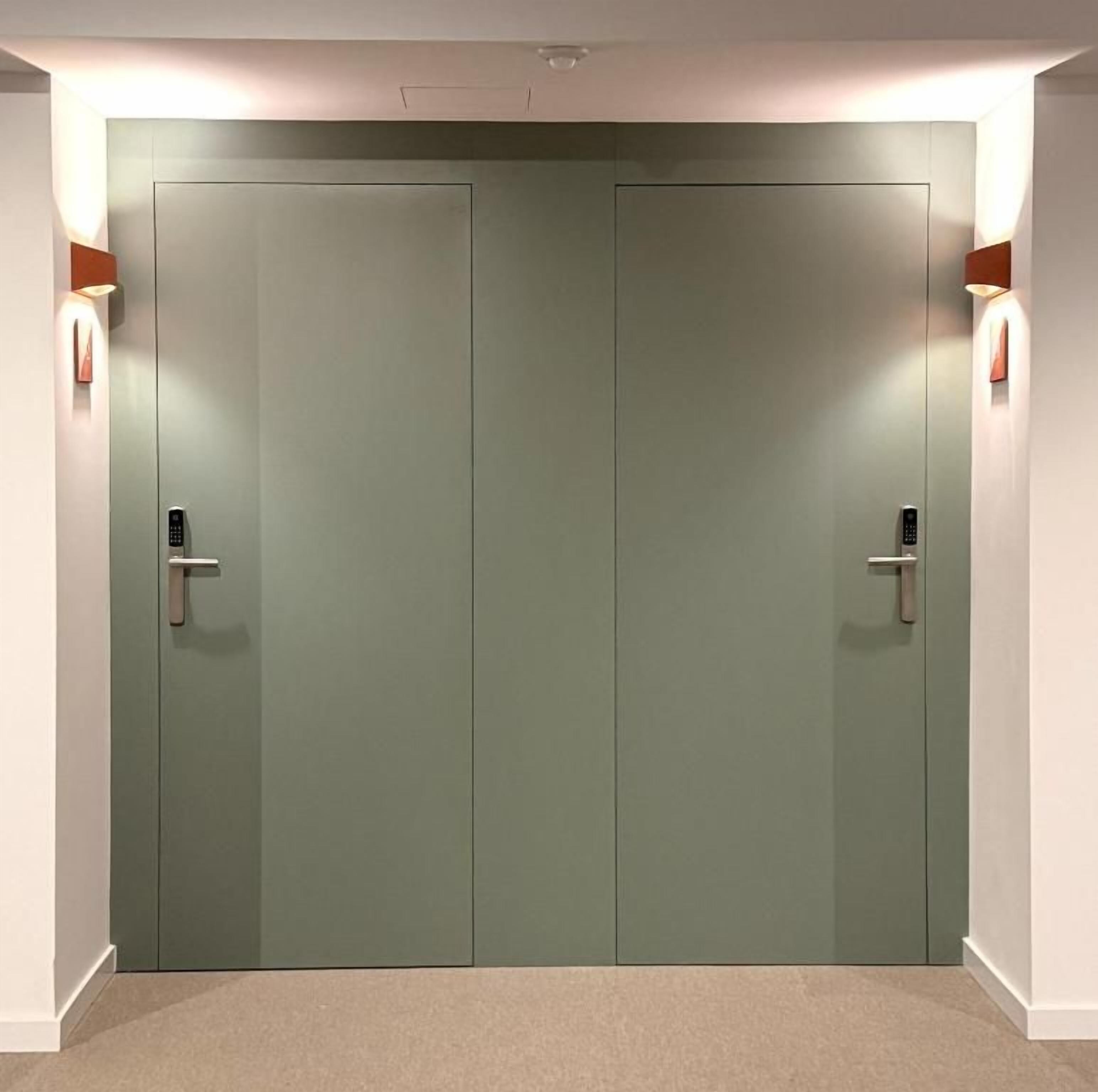 A pair of closed doors with a light switch on each, a wall-mounted light fixture on the left, and a wall-mounted light fixture on the right.