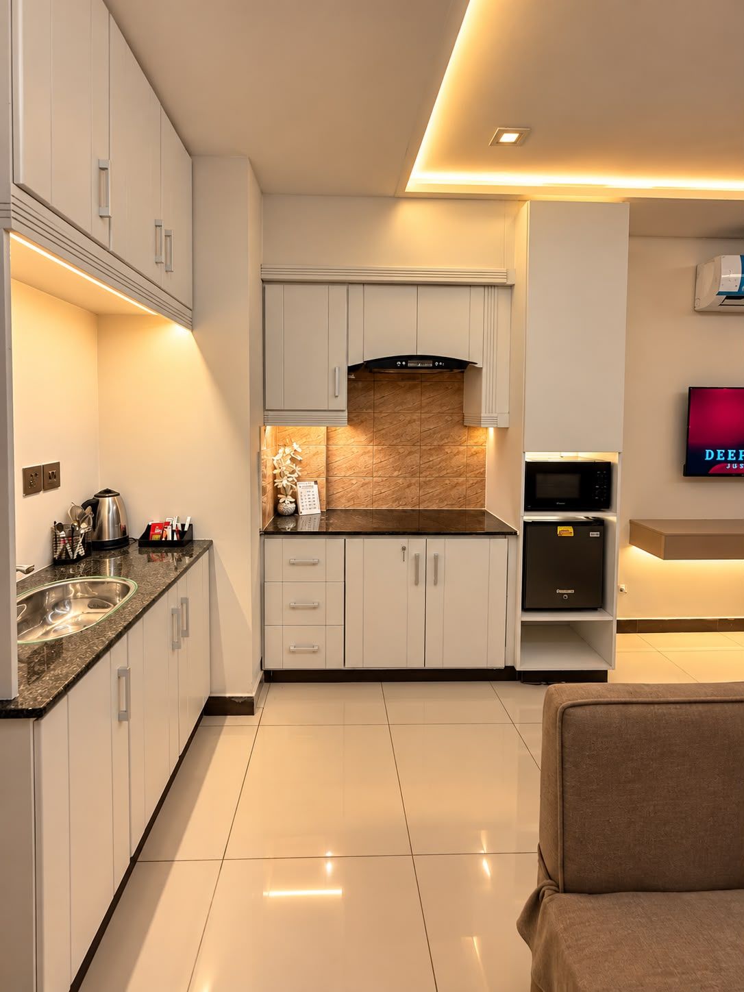 A modern kitchen with white cabinets, a granite countertop, and a built-in oven.
