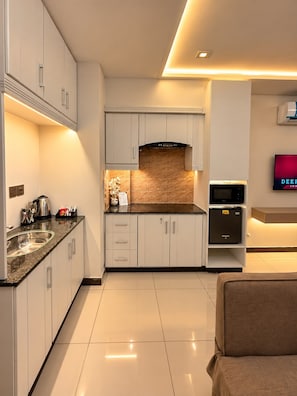 Eine moderne Küche mit weißen Schränken, einer Granit-Arbeitsplatte und einem eingebauten Backofen.