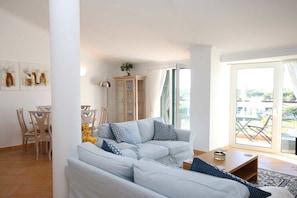 A living room with a sofa set, a dining table with chairs, and a cabinet. - Fabulous holiday apartment (Quarteira)