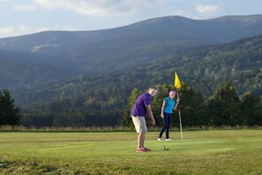 A golf course with a flagstick and players. - with indoor pool and sauna (Jilemnice Benecko)