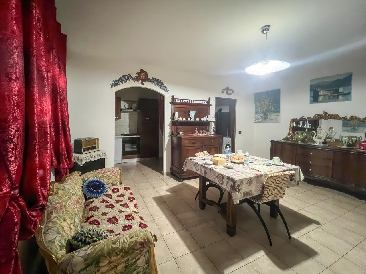 Ein Wohnzimmer mit einer Couch, einem Esstisch und einer Küchenzeile.