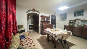 Ein Wohnzimmer mit einer Couch, einem Esstisch und einer Küchenzeile.