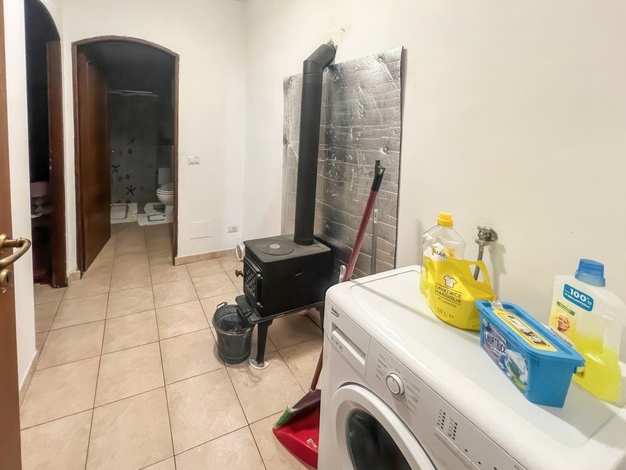 Une buanderie équipée d’un lave-linge, d’un sèche-linge et de produits de nettoyage.