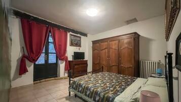 Une chambre à coucher avec un lit, une armoire, un téléviseur et un radiateur.