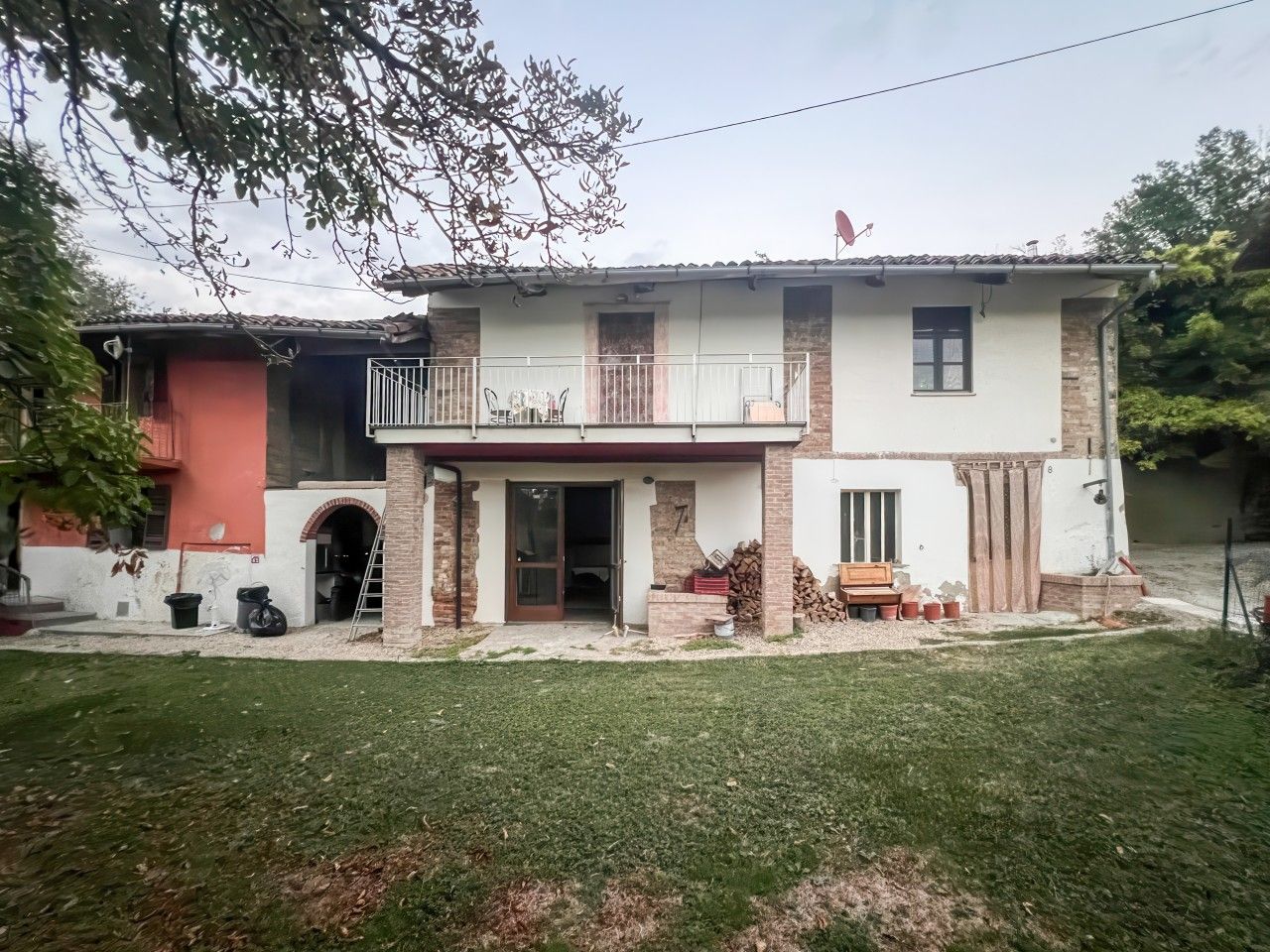 Une maison à deux étages avec un balcon, un garage et une porte d’entrée.